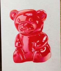 a red gummy bear sitting on top of a piece of paper with the shape of a teddy bear