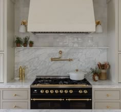 a stove top oven sitting inside of a kitchen next to white cupboards and counter tops