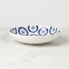 a blue and white bowl sitting on top of a marble counter