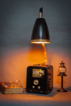 a lamp that is sitting on top of a table next to a box and other items