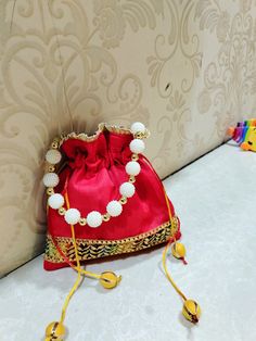 A unique handmade potli bag..using raw silk fabric and embellishments..You can carry it to any occasion..ve it small outing or a wedding Fancy Potli Bags, Diwali Dori Work Potli Pouch Bag, Elegant Navratri Potli Bag With Gota Work, Festive Gota Work Pouch Potli Bag, Diwali Handwork Pouch Potli Bag, Festive Zari Work Potli Bag, Diwali Handwork Potli Pouch Bag, Wedding Pouch Bag With Gota Work, Navratri Zari Work Potli Bag