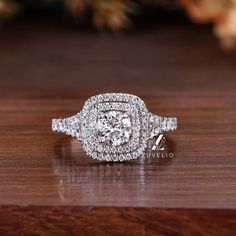 a diamond engagement ring sitting on top of a wooden table