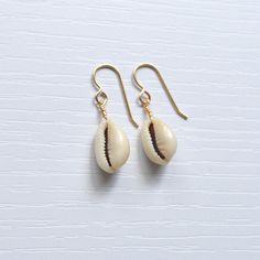 Simple & cute describe these whole cowrie shell earrings! They're the perfect accessory to wear with your favorite casual outfit when you're out & about. Please allow for variations in size and shape of shells as each is unique. Handmade Cowrie Shell Earrings For Gift, Handmade Cowrie Shell Earrings As Gift, Trendy Shell-shaped Jewelry Gift, Casual Shell Jewelry Gift, Beach Jewelry For Pierced Ears, Shell-shaped, Casual Gold Drop Earrings, Cowrie Shell Earrings For Gifts, Bohemian Cowrie Shell Earrings For Summer, Trendy Beach Drop Earrings