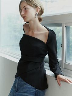 This product is a Square Neck Tulip Blouse that combines a structured square neckline with the soft, flowing lines of a tulip-shaped body, offering a blend of geometric and organic design elements. The blouse features a fitted waist that accentuates the silhouette, while the peplum detail adds a touch of drama and femininity to the overall aesthetic. Crafted to provide a sophisticated and polished look, this piece is perfect for both formal and casual settings. - The blouse boasts a square neckline that frames the collarbones and lends a modern edge.- A peplum waist creates a flattering tulip-like silhouette that enhances the garment's elegance.- The long sleeves add a traditional touch, balancing the contemporary neckline and fitted bodice.- Constructed with a blend of materials that Elegant Blouse With Stretch And Asymmetrical Neckline, Modern Top With Asymmetrical Neckline For Fall, Modern Fall Tops With Asymmetrical Neckline, Modern Fitted Blouse With Asymmetrical Neckline, Elegant Blouse With Asymmetrical Neckline And Stretch, Modern Tops With Asymmetrical Neckline For Fall, Elegant Blouse With Asymmetrical Neckline, Modern Tops With Asymmetrical Neckline For Night Out, Modern Asymmetrical Neckline Top For Night Out