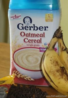 two bananas and some cereal on a table next to a bottle of gerber oatmeal