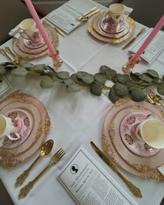 the table is set with pink and gold china