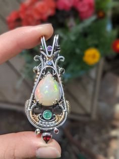 "Fire Opal Wire Wrapped Pendant This is hands down the finest opal I've ever set into a piece to date. I tried my best to capture the stone, but photos hardly do it justice B A L A N C E C O L L E C T I O N \"Striving to find equilibrium in all aspects of life\" D E T A I L S MATERIALS 1x Fire Opal (Welo Opal, Ethiopia) 4x Sapphire (B,Y,O) 1x Amethyst 1x Emerald 1x Garnet METALS .925 Sterling Silver 14k Gold-filled DIMENSIONS 2.5 x 1.1\" S T O N E M E A N I N G S OPALS are known to spark optimis Fusion Teardrop Multi-stone Jewelry, Ethiopian Opal Gemstone Jewelry For Jewelry Making, Fusion Style Teardrop Multi-stone Jewelry, Fusion Multi-stone Teardrop Jewelry, Fusion Style Multi-stone Teardrop Jewelry, Unique Ethiopian Opal Oval Jewelry, Handmade Ethiopian Opal Elegant Jewelry, Handmade Ethiopian Opal Jewelry For Anniversary, Unique Ethiopian Opal Gemstone Jewelry