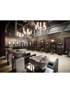 the interior of a barbershop with chandeliers hanging from the ceiling and chairs in front of them