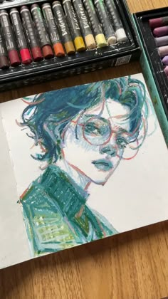 a drawing of a man with glasses and green shirt next to some crayons