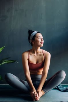 a woman is sitting on the floor with her eyes closed and looking up at something