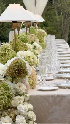 a long table with white and green flowers on it