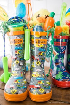 the children's rain boots are lined up on the table with toys in them