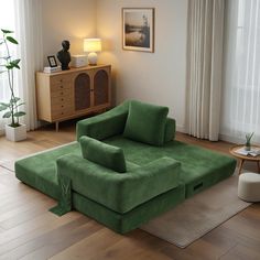 a living room filled with furniture and a green couch in front of a large window