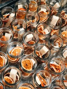 many glass jars filled with orange slices and marshmallows