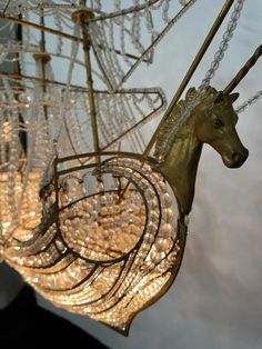 a carousel with lights hanging from it's sides and a horse head on top