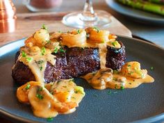 the steak is covered in sauce and garnished with parsley