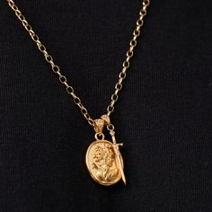 Carry the spirit of Achilles with you as you face challenges head-on, overcome obstacles, and achieve greatness in every aspect of your life. This 18K gold pendant features a detailed engraving of the legendary Greek warrior Achilles. It showcases his iconic helmet, adorned with a crest and laurel wreath—symbols of victory and honour. Hanging alongside the medallion is a finely detailed sword with an ornate hilt. Both pieces are suspended from a decorative filigree bail, classic 4mm link chain, Warrior Style Gold Necklaces As Gift, Greek Accessories, Strive For Greatness, Ice Necklace, Greek Warrior, Laurel Wreath, Pearl Gemstone, Pendant Gold, Oval Pendant