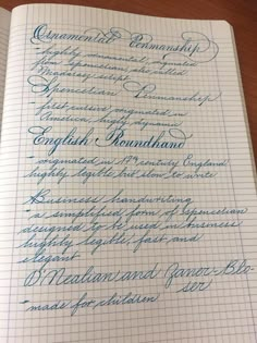 the writing is lined up on top of an open notebook, with blue cursive ink