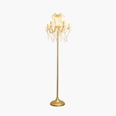 a gold colored floor lamp with many lights on it's sides and a white background