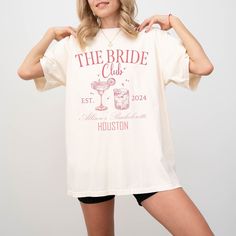 ✨CONTACT US FOR MORE COLORS✨ 👰 Make your bridal party stand out with our custom bridal party t-shirts! 🎉 Whether you're celebrating a custom bachelorette party, bridal shower, or the big day itself, these personalized tees add a fun and stylish touch to your wedding festivities. Choose from a variety of designs, colors, and sizes to match your wedding theme and suit every member of your bridal party. Made with high-quality materials for comfort and durability, these tees are perfect for gettin White Bridal T-shirt With Short Sleeves, White Custom Print T-shirt For Bachelorette Party, Fitted Custom Print T-shirt For Party, Summer Short Sleeve T-shirt For Bridal Shower, Summer Bridal Shower Short Sleeve T-shirt, Summer Wedding Tops With Graphic Print, White Short Sleeve T-shirt For Bachelorette Party, White Custom Print Top For Bachelorette Party, White Fitted T-shirt For Bachelorette Party