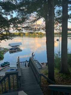 the stairs lead down to the dock where boats are docked on the water and trees