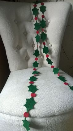 an upholstered chair decorated with holly and poinsettis for the holiday season