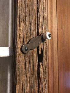 an open door with a handle on it and wood grained wall behind the door