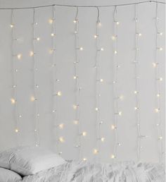 a white bed topped with pillows and lights