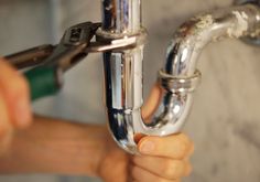 a person is fixing a pipe on a wall