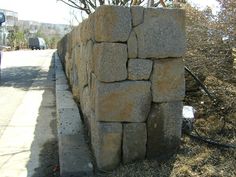 a large rock wall sitting on the side of a road