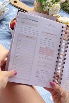 a woman is holding a daily planner in her hand