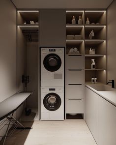 a washer and dryer in a small room with shelves on the wall behind them