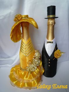 two wine bottles are dressed up in fancy clothes and hats for a wedding or special occasion