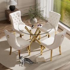 a cat sitting on the floor in front of a round glass table with white chairs