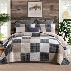 a bed with a black and white checkered comforter set on top of it