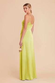 a woman in a lime green dress with her back to the camera, looking down