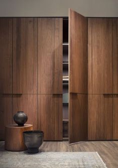 an empty room with wooden cabinets and vases on the floor in front of it