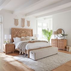 a bedroom with white walls and wooden furniture