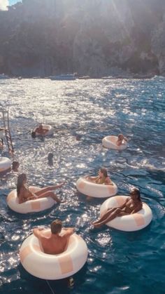 several people floating on inflatable rafts in the water