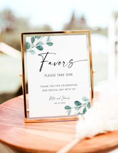 a sign that says favors on it sitting on a wooden table next to some feathers