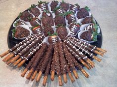 chocolate covered strawberries and pretzels arranged on a platter with football decorations