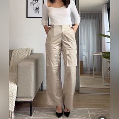 High-Waisted Pants With Side Pockets, False Back Flap Pockets, And Patch Pockets At Legs. Front Zip And Metal Hook Closure. High Waist Wide Leg Cargo Pants For Work, Khaki Ankle-length Pants, High Waist Cargo Style Work Pants, High Waist Cargo Work Pants, Chic Trousers With Cargo Style, Chic Cargo Style Long Bottoms, Chic Cargo Trousers, Chic Cargo Style Trousers, Chic Cargo Style Long Pants