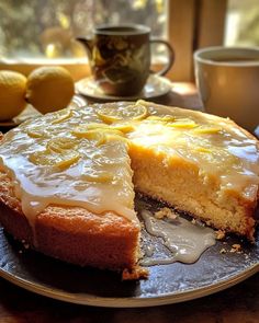 there is a cake with lemons on the table next to cups and saucers