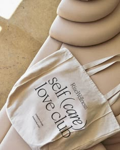 a white bag sitting on top of a table next to a pair of beige shoes