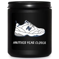 a black canister with a white and blue sneaker on the side that says, another year closer