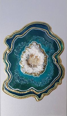 a blue and gold plate with white speckles on the center, in an ornate design