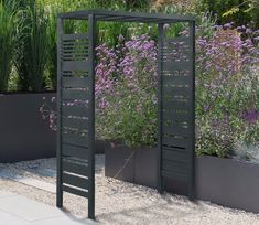 an outdoor garden with plants and flowers in the back ground, along with two large planters on either side