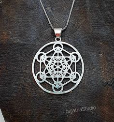 HANDMADE Beautiful Metatron's Cube  pendant with a complementary decorated chain. Metatron's Cube includes all 5 Platonic Solids hidden inside, symbolizing the underlying geometric patterns found throughout our universe. ... It's named after Archangel Metatron, who watches over the flow of energy in creation and provides a connection to the divine. Made by hand with hight quality of brass, Nickel free.  Aprox Heigh pendant: 4.9 cm Aprox Diameter pendant: 3.8 cm Aprox optional chain Lenght: 44 cm Nickel Free Pendant Necklace For Festivals, Nickel-free Pendant Necklace For Festivals, Symbolic Metal Necklaces For Festivals, Symbolic Sterling Silver Necklace For Festivals, Symbolic Jewelry For Festivals, Symbolic Round Pendant Jewelry For Festival, Nickel-free Necklaces For Festivals, Symbolic Round Pendant Necklace For Festivals, Symbolic Pendant Necklaces For Festivals