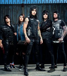 a group of young men standing next to each other in front of a metal fence