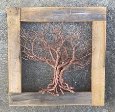 a wooden frame with a tree in it on the concrete floor next to a wall